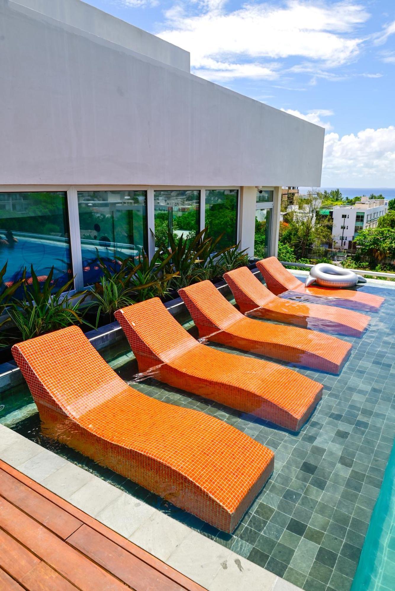 Aloft Playa Del Carmen Hotel Ngoại thất bức ảnh Sunbathing chairs at a pool